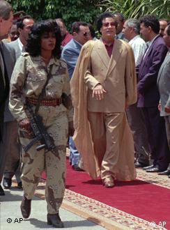 Libyan President Col. Moammar Gadhafi arrives at Qubba Palace in Cairo accompanied by one of his female bodyguards Saturday, May 25, 1996. Egyptian President Hosni Mubarak walks behind Gadhafi. The Libyan President is expected to stay in Egypt for at least three days. (AP Photo/Enric Marti)
