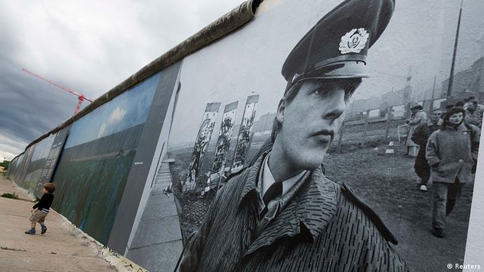 Ein Panoramabild auf der Berliner Mauer zeigt ein historisches Foto eines Wächters der Berliner Mauer.
(c) REUTERS/Thomas Peter 