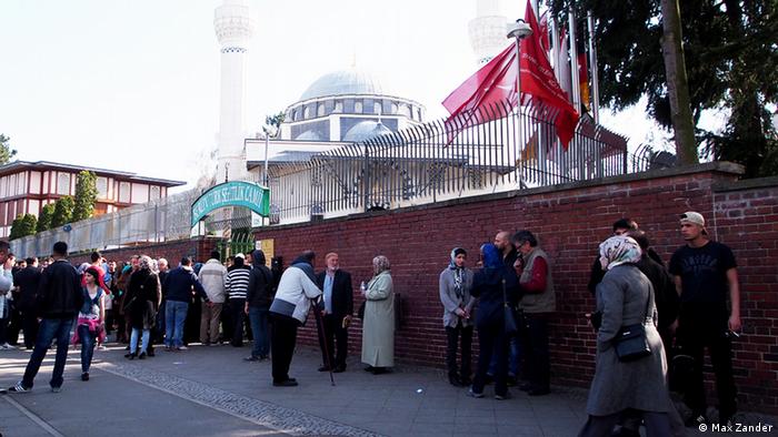 Gläubige vor der Grundstücksmauer der Sehitlik-Moschee