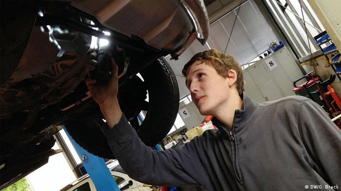 Der Auszubildende Simon Liegl vom bayerischen Autohaus Gramsamer macht einen Reifenwechsel in der Werkstatt. (Foto: DW/Gerhard Brack)