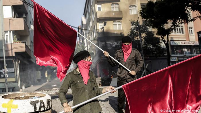 Left-wing militants wave red flags during clashes with Turkish police officers on July 25, 2015 at Gazi district in Istanbul