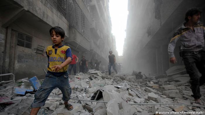 Menino foge de explosão em Aleppo, na Síria