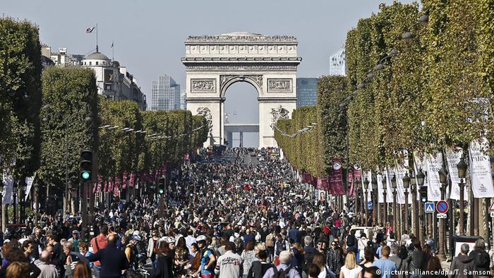 Pedestres circulam na Avenida Champs-Élysées