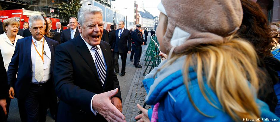 Chanceler federal Merkel (e.) e presidente Gauck (c.) a caminho de culto ecumênico em Frankfurt