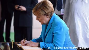 Kansela Merkel akisaini kitabu cha wageni akiwa New-Delhi