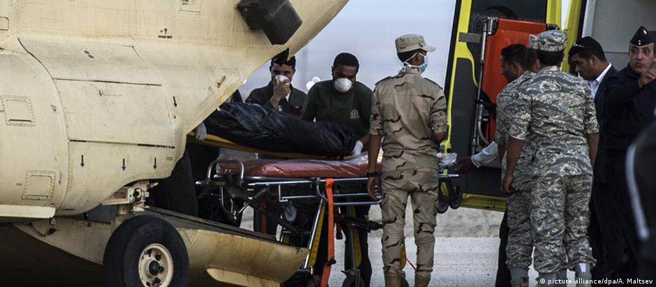 Equipes de resgate egípcias transportam corpo de vítima de desastre com avião russo