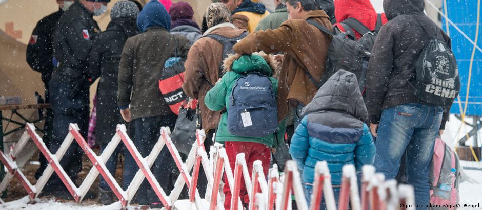 Sob neve, refugiados aguardam para seguir viagem na fronteira da Alemanha com Áustria