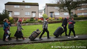 four people pulling luggage along a street

Copyright: Getty Images/Ch. Furlong

