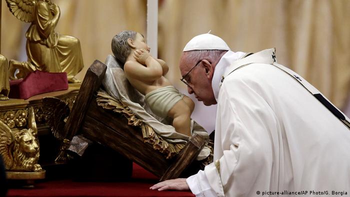 Pope Francis kisses a statue of Baby Jesus as he celebrates the Christmas Eve Mass in St. Peter's Basilica at the Vatican, Thursday, Dec. 24, 2015.