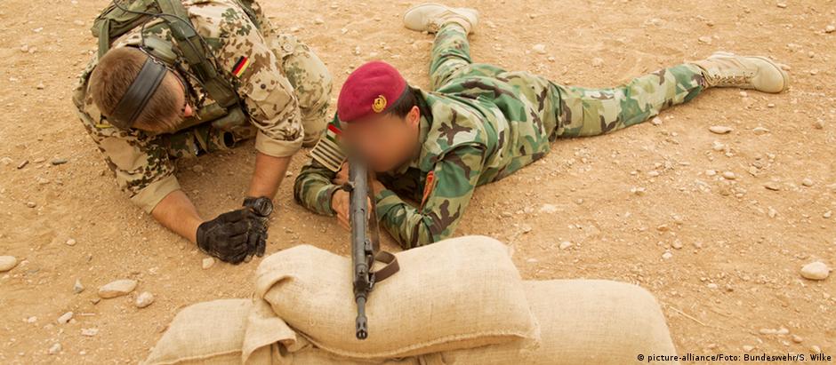Militar alemão treinando combatente peshmerga com um rifle de assalto G3