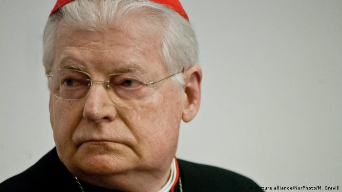 Cardinal Angelo Scola of Milan poses in full religious dress, including a large cross dangling from his neck.