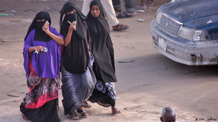 Three veiled women walking along a street