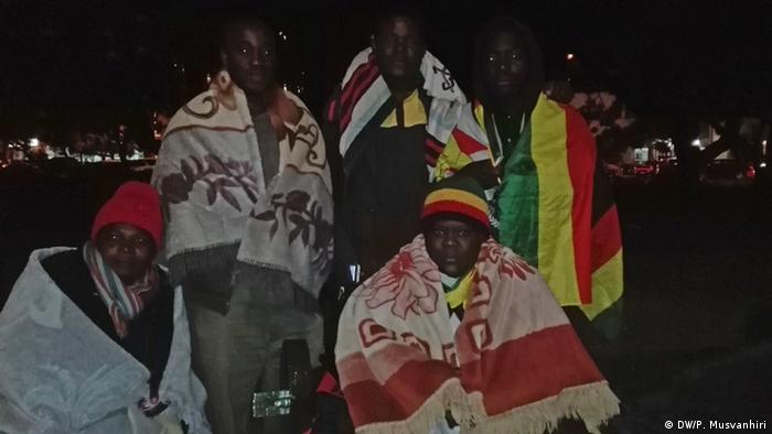 Activists of the 'Occupy Africa Unity Square' wrapped in national flags at night in Harare