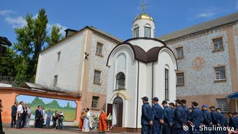Заключенные Лукьяновского СИЗО на фоне церкви