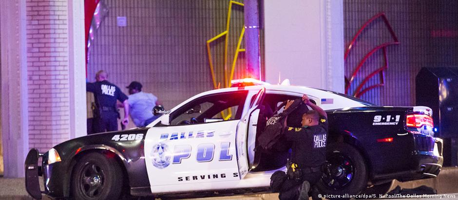 Policial se protege durante tiroteio em Dallas: cinco agentes foram mortos