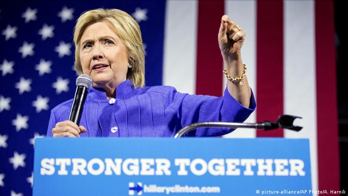 Democratic nominee Hillary Clinton gestures during a speech, with a giant US flag behind her.