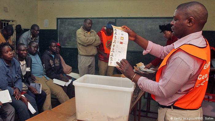 Zambian Electoral Commission officer holds a ballot paper during the vote counting process in a polling station