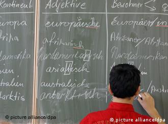 Ein Schüler schreibt deutsche Wörter an die Tafel