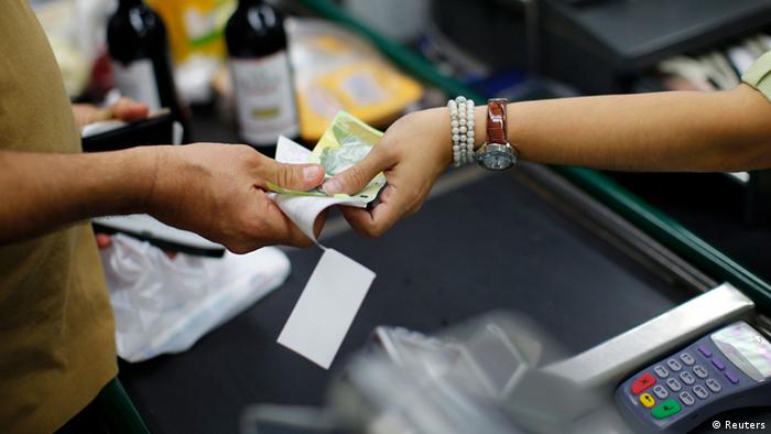 Caixa de supermercado em Caracas recebe pagamento de cliente