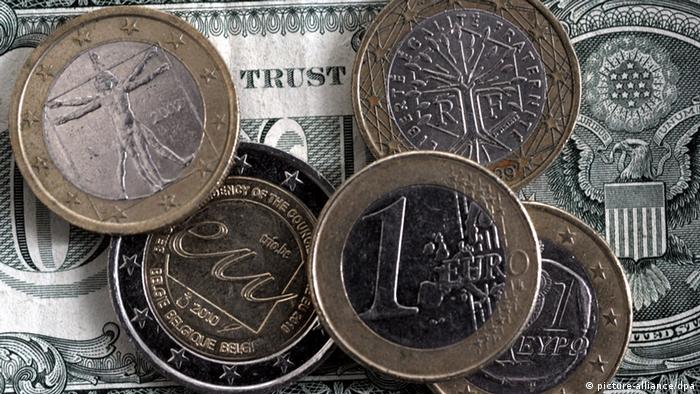 Монеты евро на фоне долларовой купюры