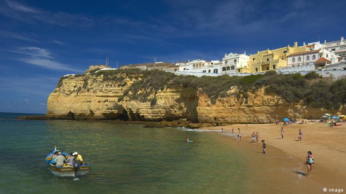 A beach in Algarve Portugal, with buildings on top of a cliff overlooking the sea. (imago)