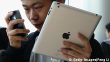 Ein Mann benutzt ein Apple iPad und ein iPhone