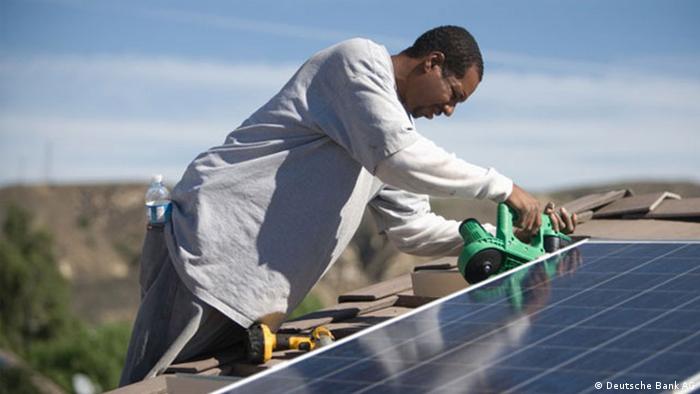 An African technician working on a solar panel.