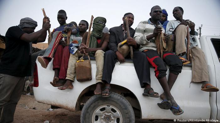 people sitting on back of a pick-up (Reuters/Akintunde Akinleye)