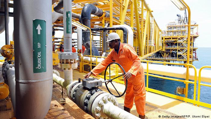 A man turns a wheel on an oil drilling platform in Port Harcourt, Nigeria