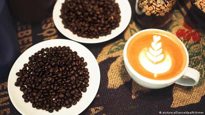 Cappuccino mit Muster Kaffeebohnen auf einem Teller (picture-alliance/dpa/N.Armer)