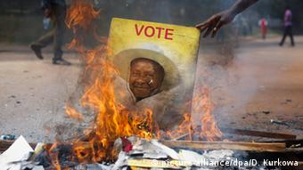 A burning campaign poster from 2016 showing Yoweri Museveni