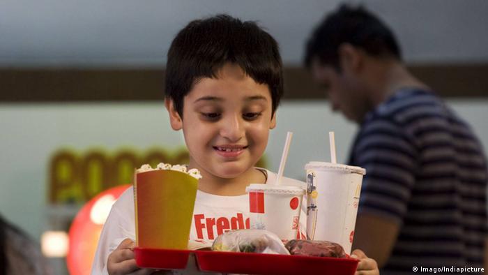 Child with greasy food and a soft drink (Imago/Indiapicture)