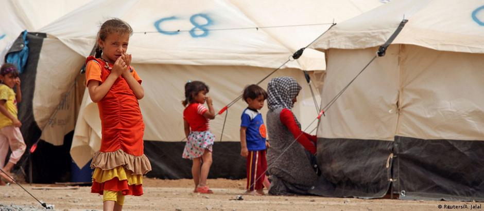 Crianças refugiadas que fugiram do Estado Islâmico aguardam num acampamento perto de Mossul