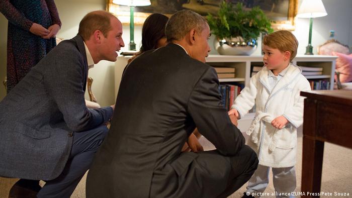 US-Präsident Barack Obama schüttelt dem kleinen Prinz George die Hände. Sein Vater Prinz William und Kate hocken neben ihm. (Foto: picture alliance/dpa/Pete Souza)