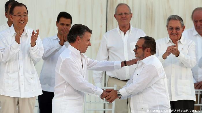 Хуан Мануель Сантос (л) та Родріго Лондоньо (п) тиснуть один одному руки під час підписання мирної угоди