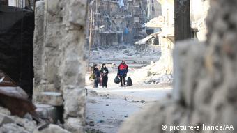 Residents escape Assad regime bombardment in the Al Moyaser neighborhood of Aleppo on November 29