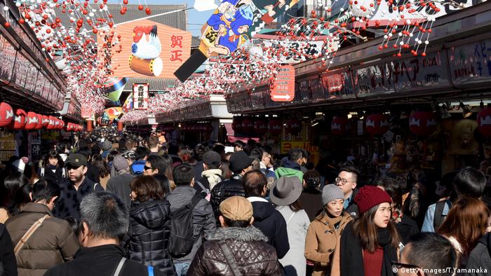 People walk underneath ornaments as they visit the Sensoji temple in Tokyo on New Year's Eve (Getty Images/T.Yamanaka)
