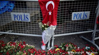 Flowers lay in front of a police barrier near the nightclub