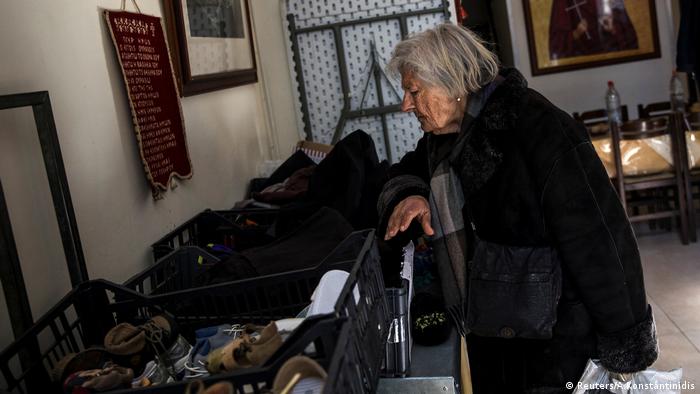 Pobreza en Grecia: una mujer busca vestimenta de donaciones.