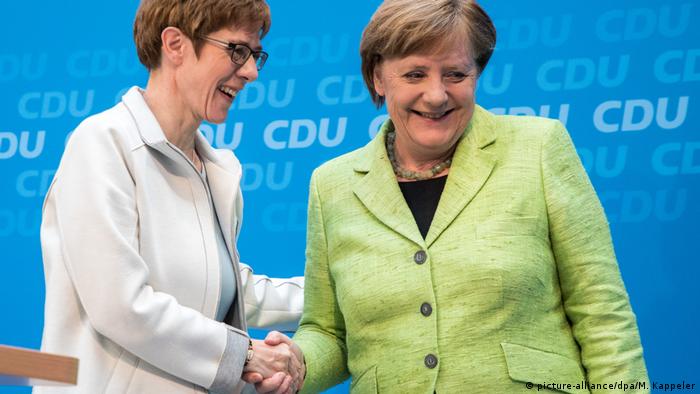 Annegret Kramp-Karrenbauer is congratulated by Angela Merkel