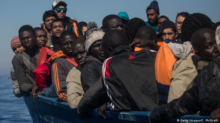 Refugees and migrants waiting to be rescued from a rickety, overcrowded boat in the Mediterranean Sea