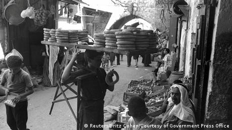 Μερικά πράγματα δεν αλλάζουν ποτέ! Και πριν από 50 χρόνια, όπως βλέπουμε στη φωτογραφία του 1967, οι νέοι περπατούσαν στα στενά δρομάκια και πουλούσαν φρεσκοψημένα σουσαμένια κουλούρια, τα «bagel» όπως τα ονομάζουν οι ντόπιοι, για ένα ευρώ. 