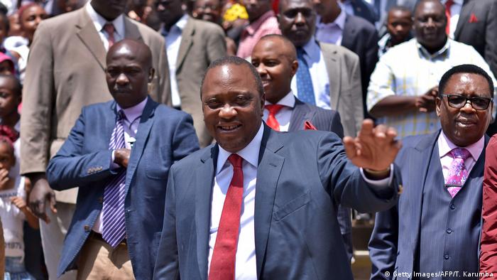 A smiling Uhuru Kenyatta with a crowd of supporters 