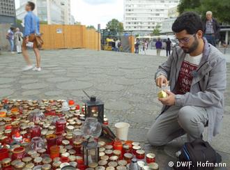 Masoud Aqil acende uma vela no local de atentado em um mercado de Natal em Berlim, em dezembro de 2016