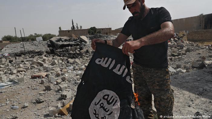 Syrien - Syrischer Kämpfer mit IS Fahne (picture alliance/AP/dpa/H. Malla)