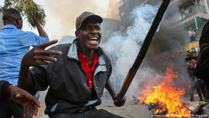 Protester in front of fire in Kenya (Picture-Alliance/AP Photo/B. Inganga)