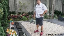 Kolumbien, Medellin, Carlos Palau steht vor dem Grab von Pablo Escobar auf dem Friedhof von Montesacro