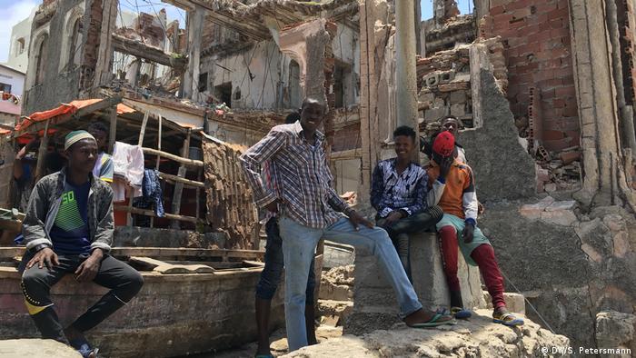   Young men are sitting in the ruins of a building (DW / S. Petersmann) 