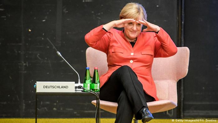 Ангеле Меркель совсем не чуждо чувство юмора. На саммите ЕС в Таллине она пытается разглядеть своих коллег.