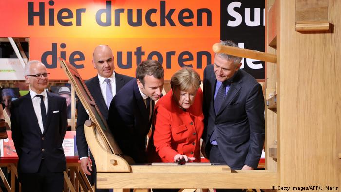 Angela Merkel and French President Emmanuel Macron look at the printing the declaration of Human Rights on a replica of the Gutenberg press (Getty Images/AFP/L. Marin)